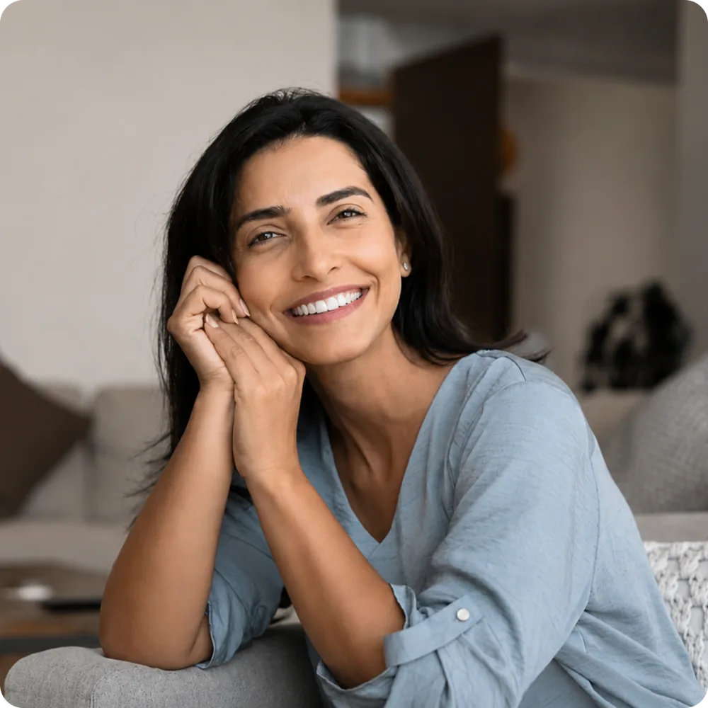 Woman smiling comfortably at home on a sofa