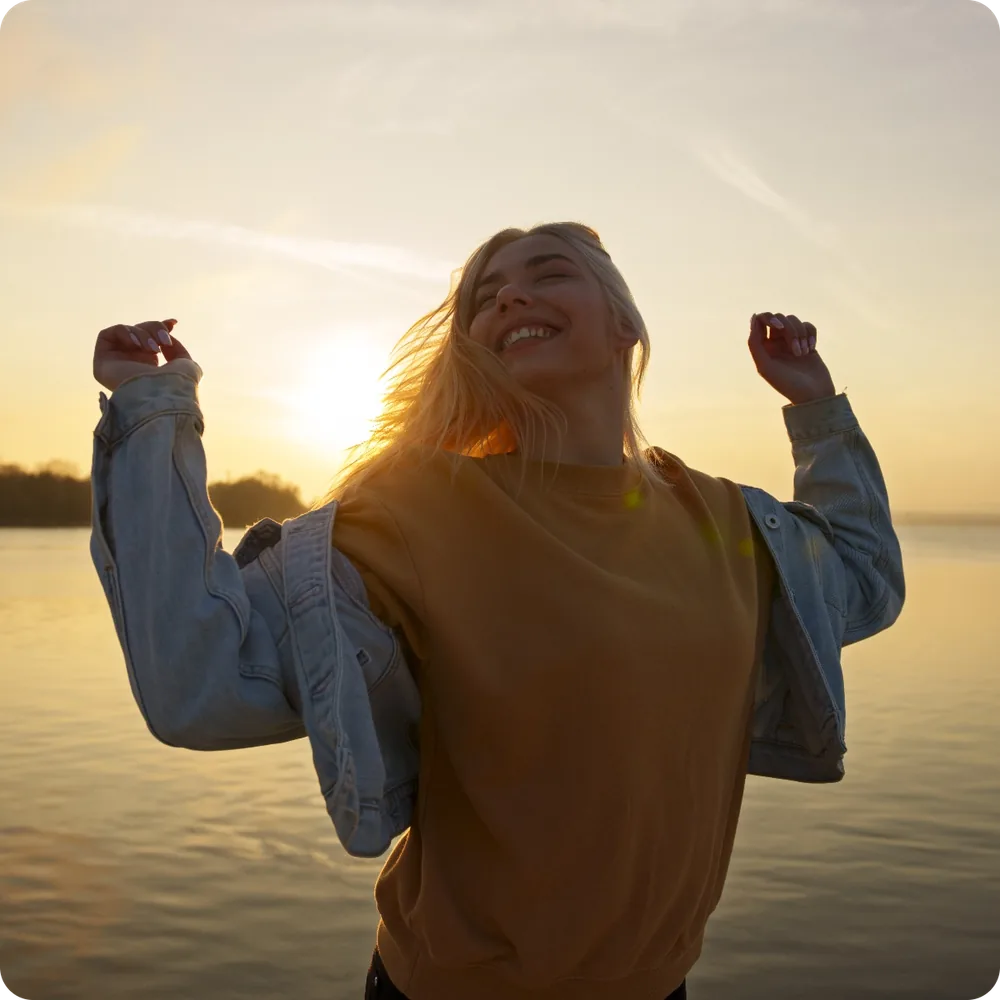 Woman looking toward the sea at sunset